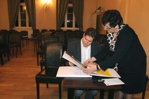 Sabina Jankowska and Stanislav Soloviev looking at the concert chronicle in the District Office in Trzebnica. Photo by Jowita Małogoska.